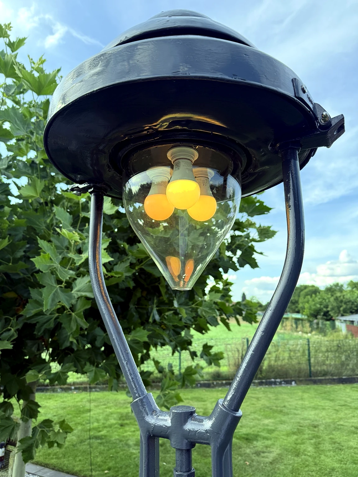 Detailaufnahme des restaurierten Laternenkopfs mit Glaskörper und warmem Licht